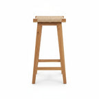 Tabouret haut en teck avec assise tressée positionné autour d’un bar extérieur en bois