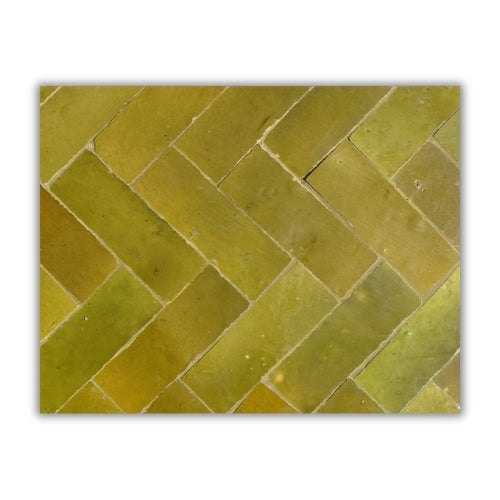 Détail du plateau en zellige marocain orange cognac posé à la main révélant texture minérale et nuances naturelles