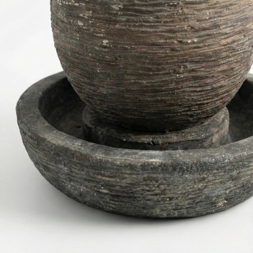 Détail de la texture minérale d’une fontaine ovale en résine ciment fibre de verre pour usage extérieur