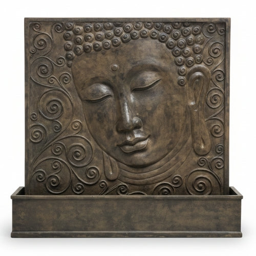 Détail du visage de Bouddha sculpté en GRC montrant les reliefs minéraux et la texture artisanale de la fontaine murale