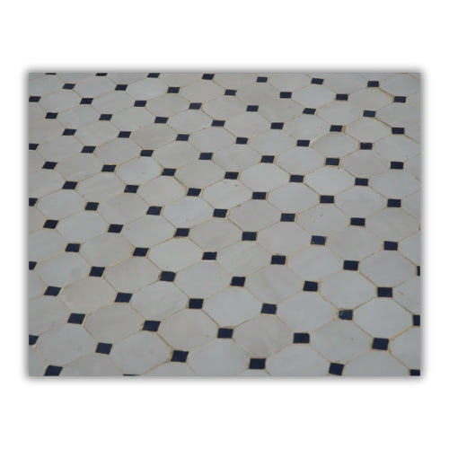 Détail de la mosaïque marocaine en zellige beige avec frise artisanale et cabochons bleus