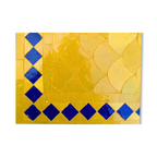 Détail du plateau en mosaïque marocaine zellige jaune avec frise bleue montrant reliefs et nuances artisanales