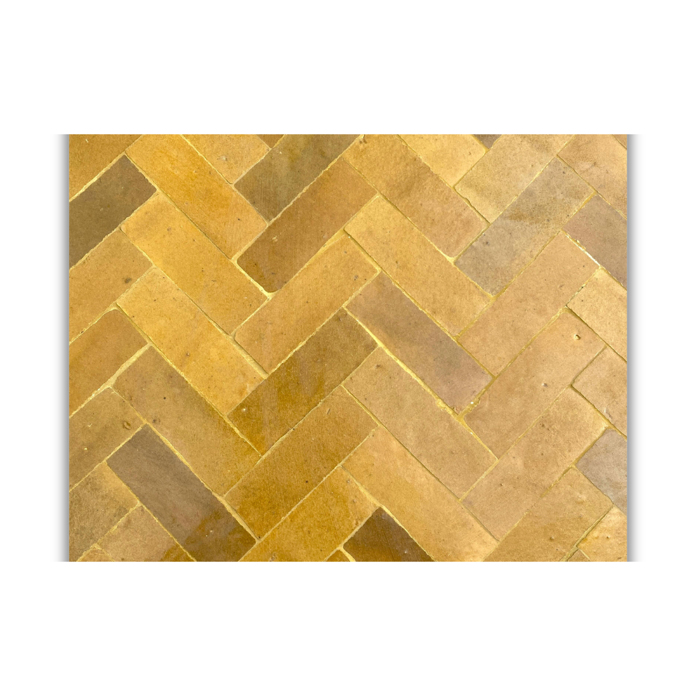 Détail rapproché des carreaux de zellige jaune posés à la main sur table extérieure en fer forgé style marocain artisanal
