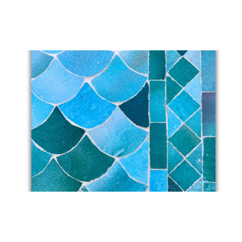 Détail du plateau en mosaïque marocaine zellige vert et bleu nuancé posé à la main sur table ovale