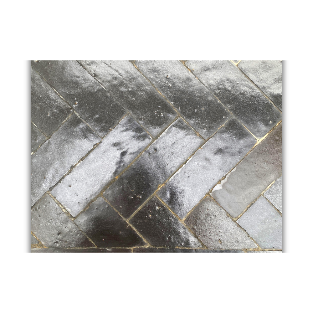 Détail de mosaïque en zellige noir artisanal avec texture émaillée et variations naturelles de teinte