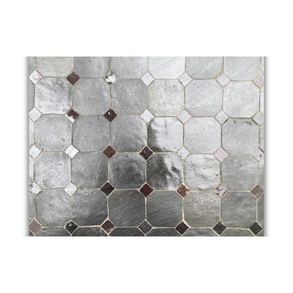 Détail de mosaïque en zellige noir artisanal avec texture émaillée et variations naturelles de surface