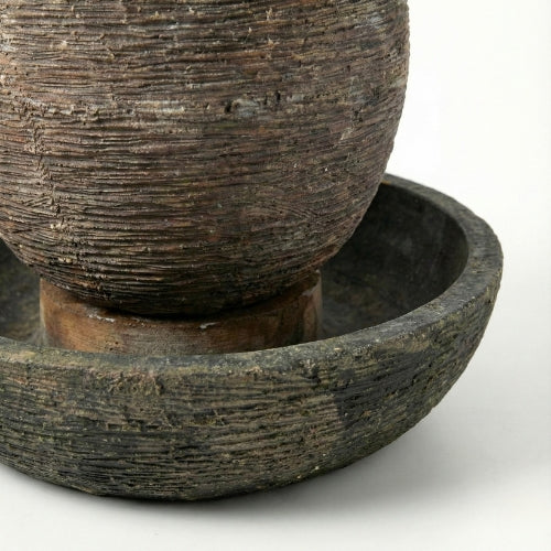 Fontaine décorative de jardin forme œuf intégrée dans un aménagement paysager végétal contemporain