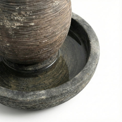 Vue rapprochée d’une fontaine ovale de jardin en résine ciment fibre de verre aux nuances naturelles