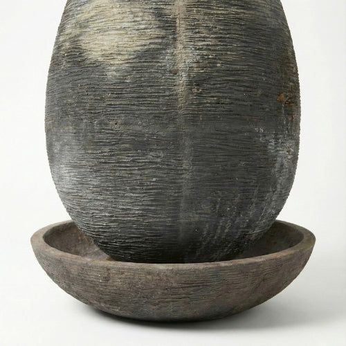 Fontaine ovale haute en résine ciment fibre intégrée dans un jardin paysager contemporain