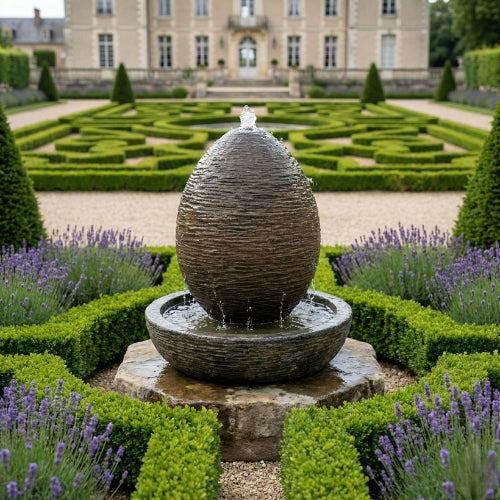 Fontaine ovale de jardin en résine ciment fibre de verre posée sur sol extérieur avec finition minérale naturelle