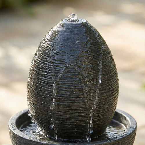 Fontaine ovale de jardin en resine ciment fibre vue de profil soulignant forme ovale