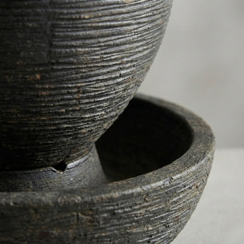 Fontaine ovale en résine ciment fibre vue de face montrant hauteur equilibrée et silhouette epuree