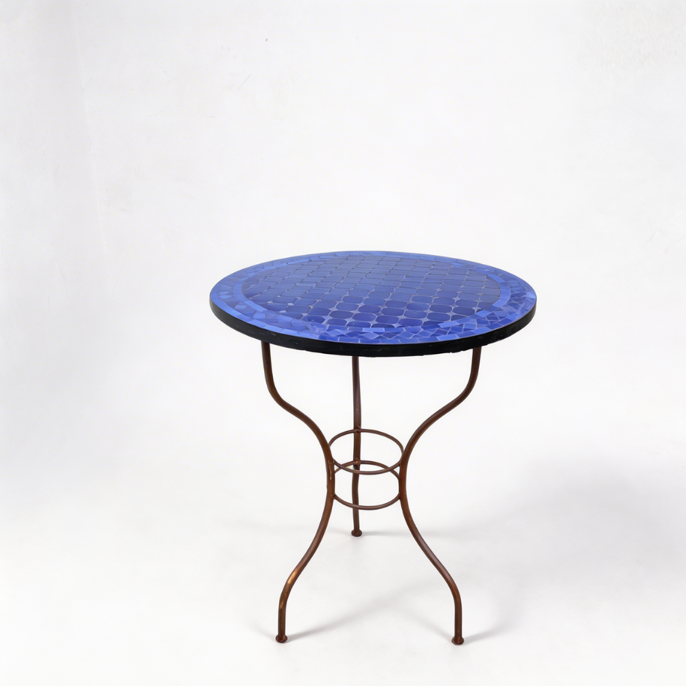 Détail du pied en fer forgé finition rouillée sous table ronde en zellige bleu pour extérieu