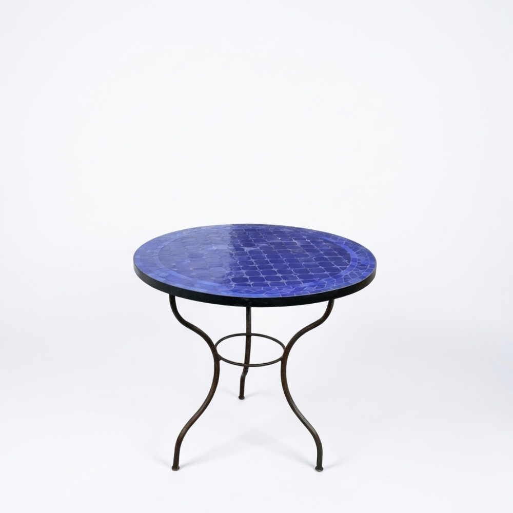 Détail du pied en fer forgé finition rouillée sous table ronde en zellige bleu pour extérieu