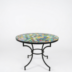 Pied en fer forgé finition rouillée sous table ronde en zellige multicolore pour terrasse et jardin