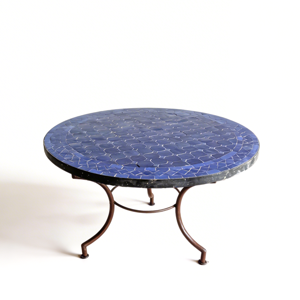Détail du pied en fer forgé finition rouillée sous table ronde en zellige bleu pour extérieu