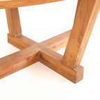 Détail du pied de la table ovale en teck massif au design naturel