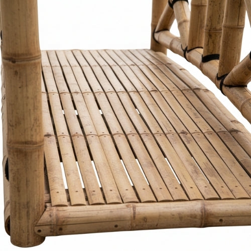 Vue latérale du petit pont en bambou naturel montrant l’arche décorative et la structure paysagère