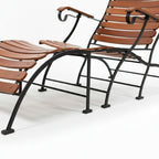 Repose-pieds en teck assorti à un transat de jardin avec piètement en métal noir