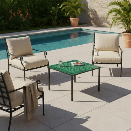 Table basse carrée en zellige marocain vert avec pieds droits en fer forgé intégrée dans un espace extérieur