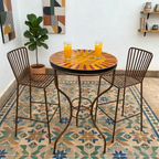 Table haute ronde en zellige orange bordeaux Ø60 cm installée sur terrasse avec pied rouillé