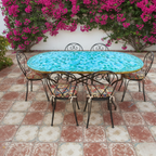 Table marocaine ovale en zellige vert et bleu nuancé installée sur terrasse extérieure dans un jardin paysager