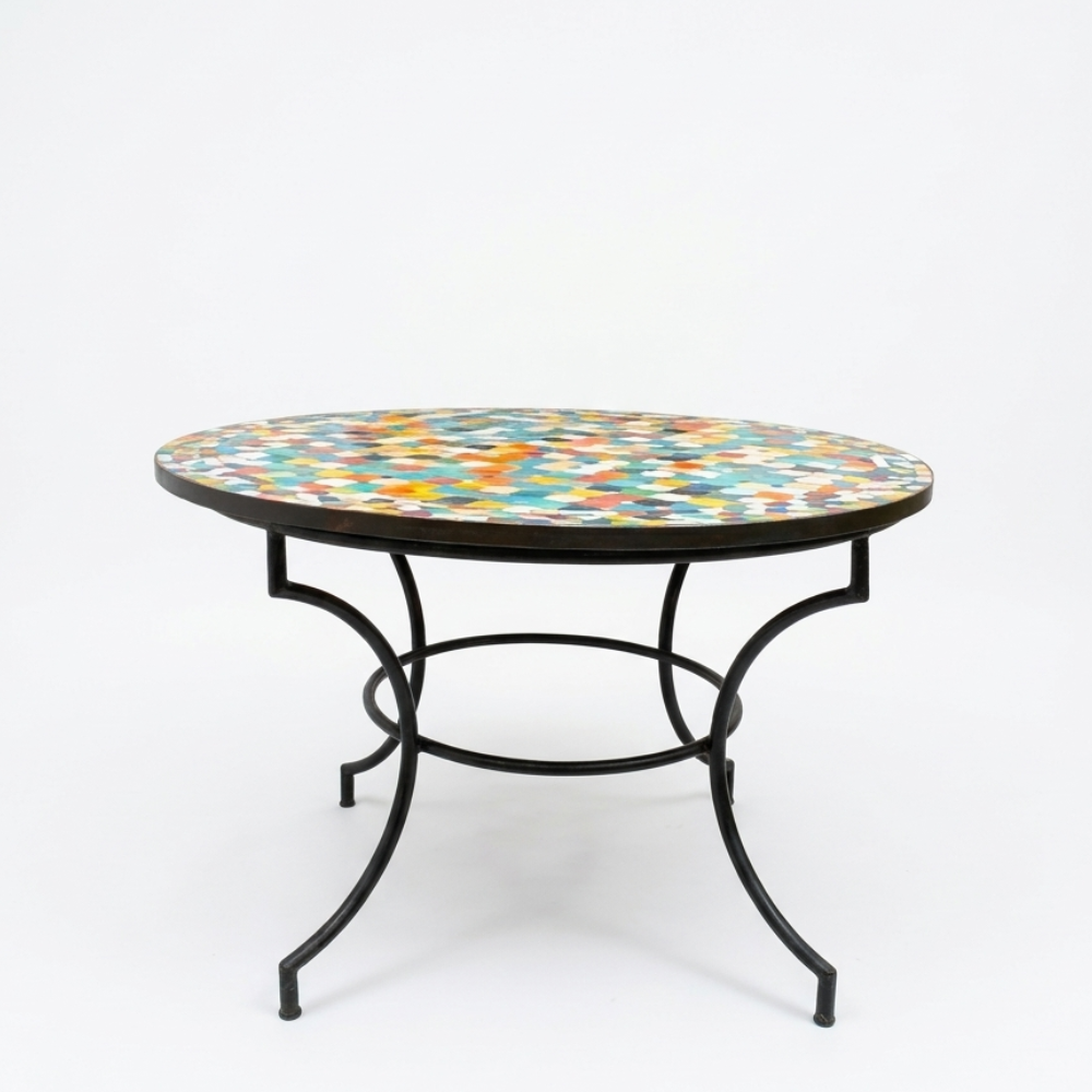 Table ronde extérieure en zellige multicolore Ø100 cm sur fond blanc avec pied en fer forgé rouillé