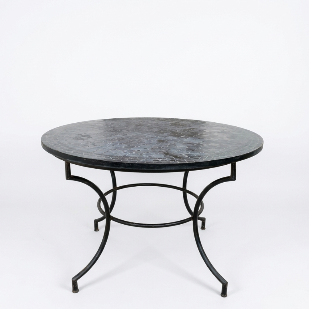 Table ronde extérieure en zellige noir Ø120 cm sur fond blanc avec structure en fer forgé finition rouillée