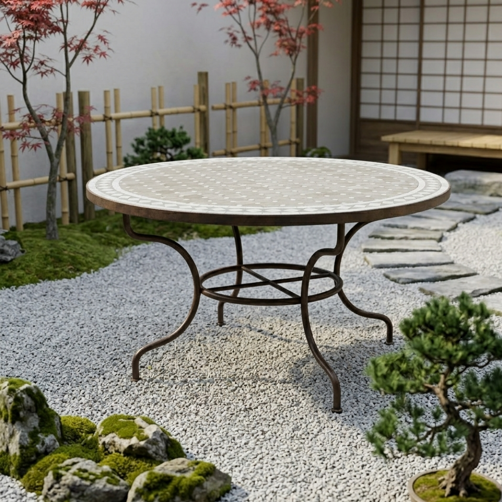 Table ronde en zellige beige Ø150 cm installée sur terrasse extérieure avec pied en fer forgé rouillé
