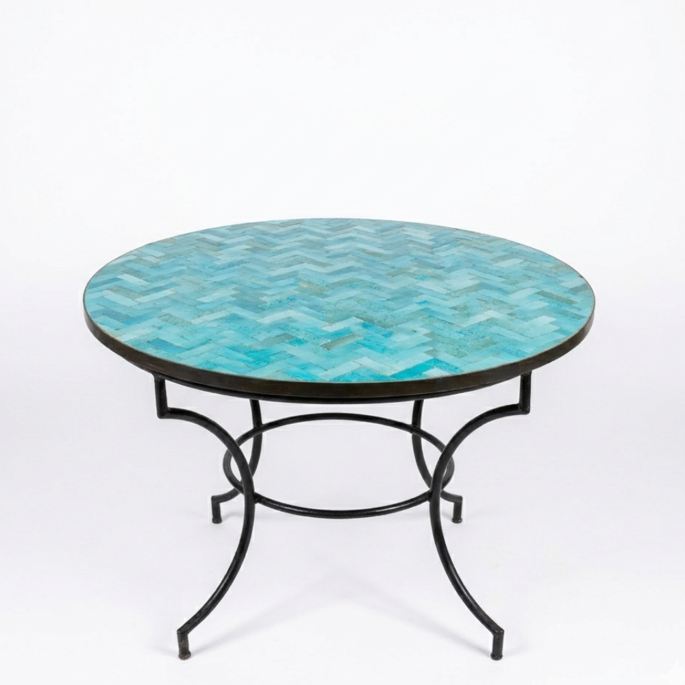 Table ronde en zellige marocain bleu ciel Ø120 cm présentée sur fond blanc avec plateau artisanal et pied fixe en fer forgé noir