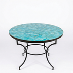 Table ronde en zellige marocain bleu ciel Ø120 cm présentée sur fond blanc avec plateau artisanal et pied fixe en fer forgé noir