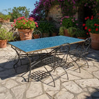 Table rectangulaire en zellige marocain bleu pétrole avec pied pliable en fer forgé installée sur terrasse extérieure
