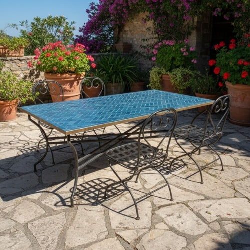 Table rectangulaire en zellige marocain bleu pétrole avec pied pliable en fer forgé installée sur terrasse extérieure