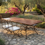 Table marocaine en zellige bordeaux motif chevrons avec pied en fer forgé noir installée sur terrasse extérieure