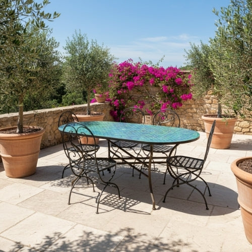 Table ovale en zellige marocain vert motif écaille avec pied pliable en fer forgé installée sur terrasse extérieure