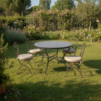 Table ronde en zellige marocain gris avec pied pliable en fer forgé installée dans un espace extérieur convivial