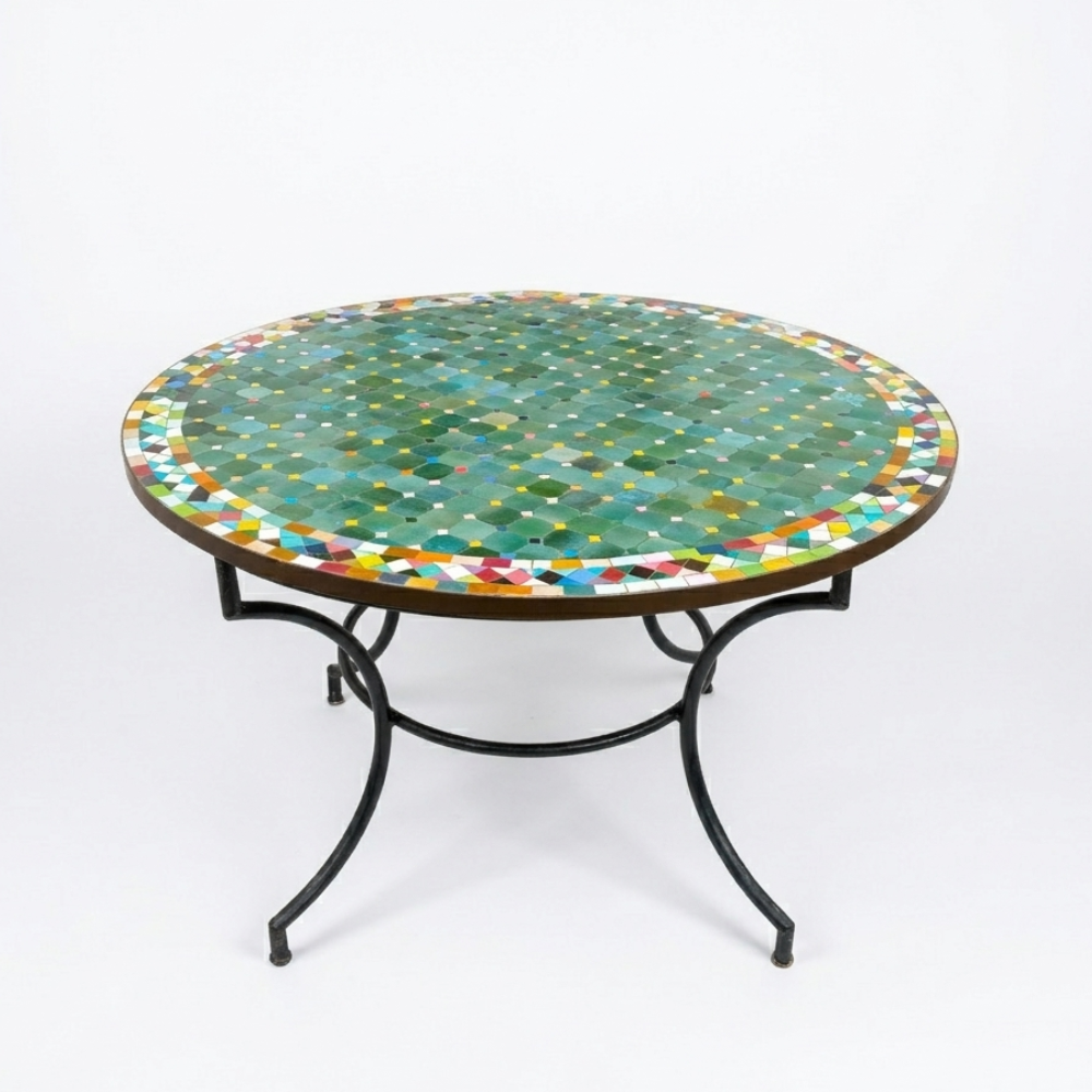 Table ronde extérieure en zellige vert Ø120 cm sur fond blanc avec frise multicolore et fer forgé rouillé