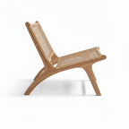 Vue de profil du fauteuil en teck massif mettant en valeur son assise large et sa structure en bois