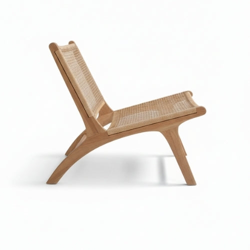 Vue de profil du fauteuil en teck massif mettant en valeur son assise large et sa structure en bois