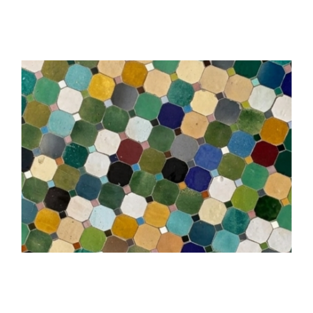 Détail du plateau en mosaïque de zellige marocain multicolore posé à la main sur table ronde extérieure